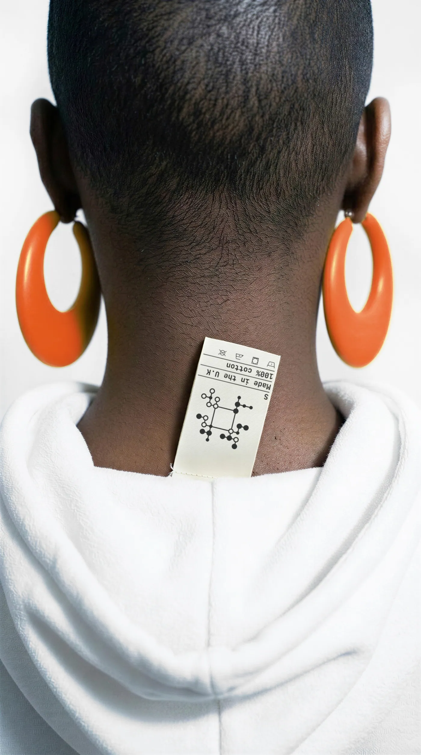 A garment care label printed with a VPI code, worn at the back of the neck.